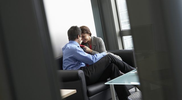 Two colleagues flirting in office